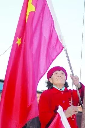 "国旗奶奶"赵桂兰将国旗系在旗杆上.