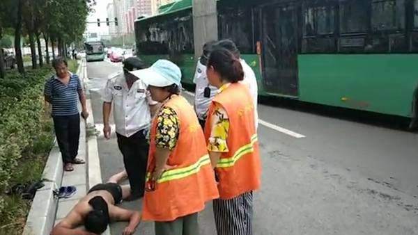 后怕！裸身小伙醉卧郑州快车道酣睡 幸被两名环卫工发现