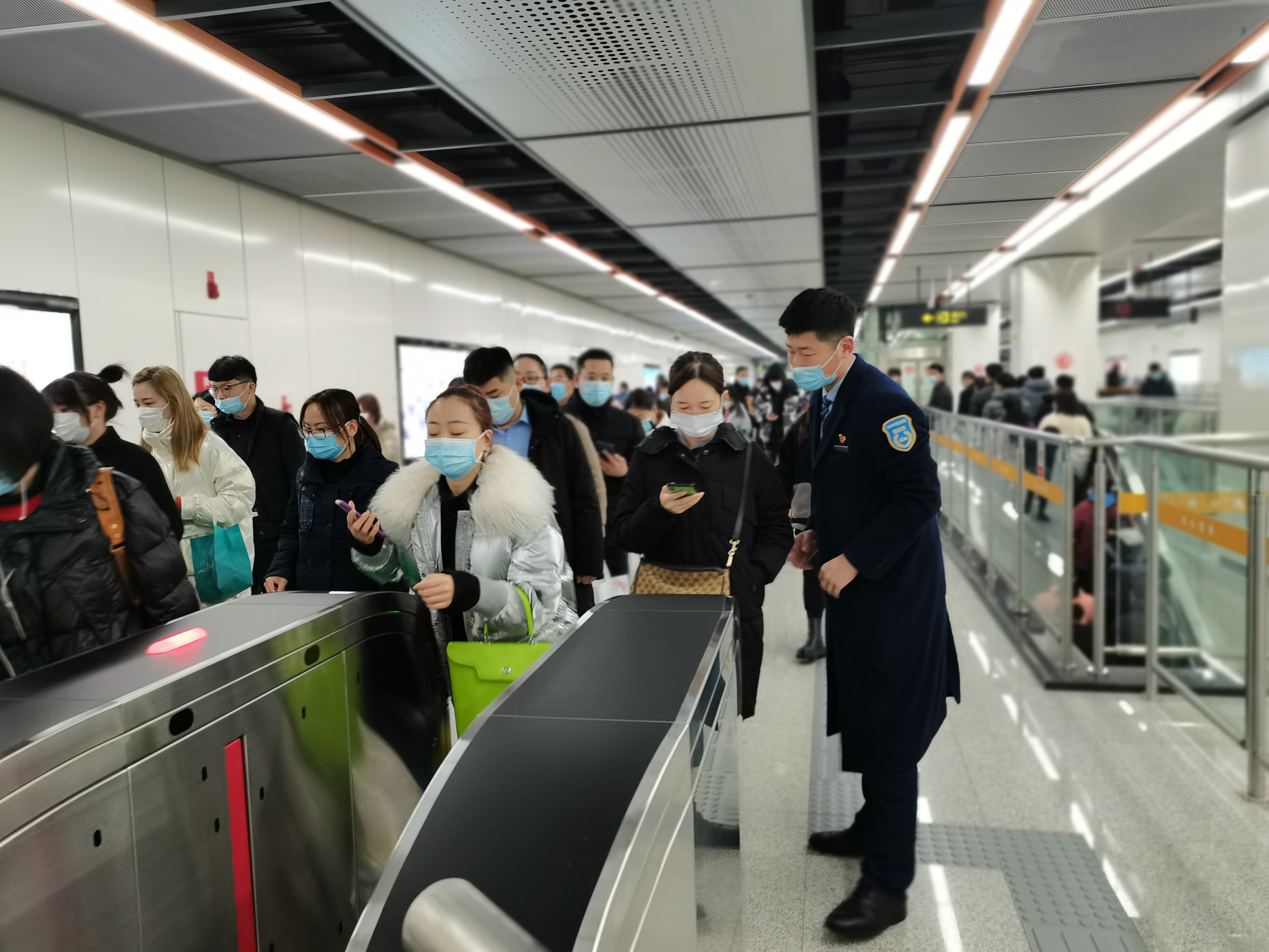 2月25日早高峰,郑州地铁迎来大客流,站务员正在引导乘客有序出站.