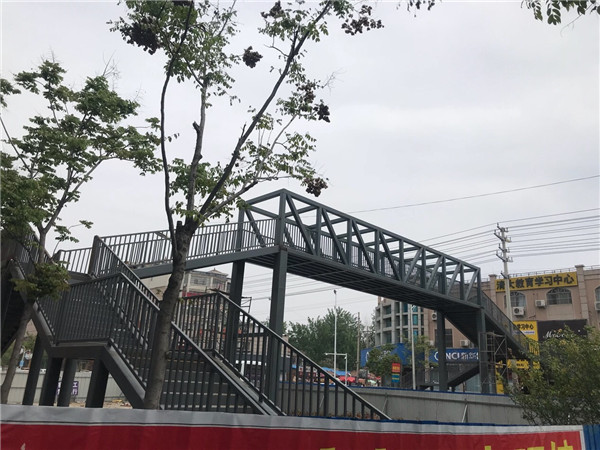 夏邑县实验中学门口,一座人行天桥主体已完工,目前尚未投入使用,上下