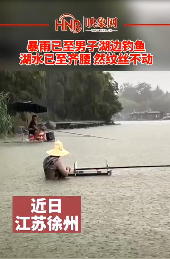 暴雨已至男子湖边钓鱼 湖水已齐腰 然纹丝不动
