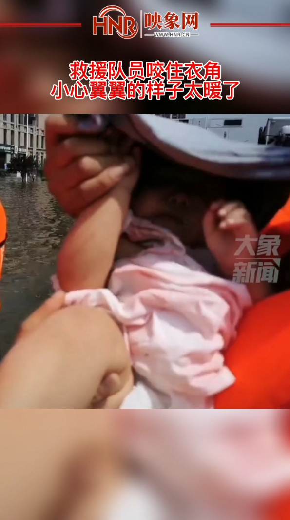 救援队员咬住衣角，让怀里的婴儿不受强光刺激，宝宝睡得香甜