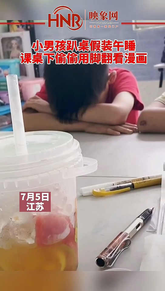 小男孩趴桌假装午睡 课桌下偷偷用脚翻看漫画