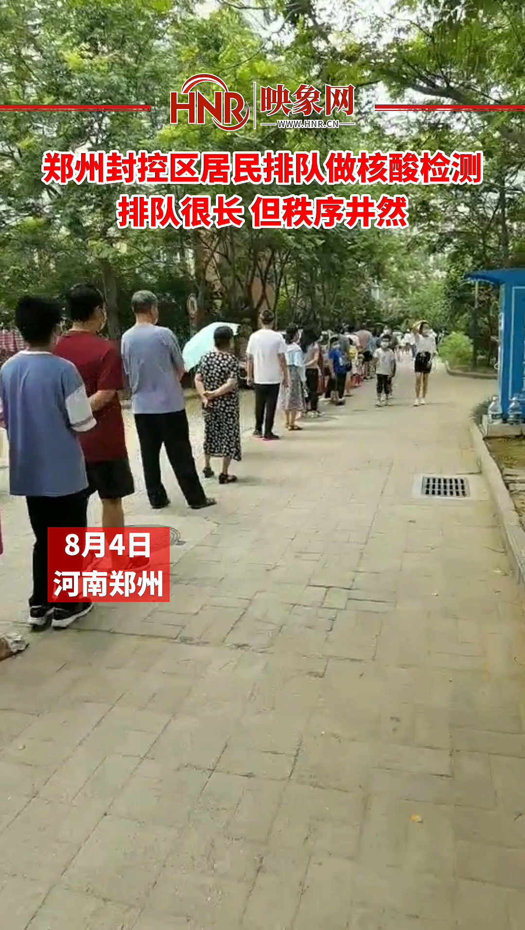 郑州封控区居民排队做核酸检测 排队很长 但秩序井然