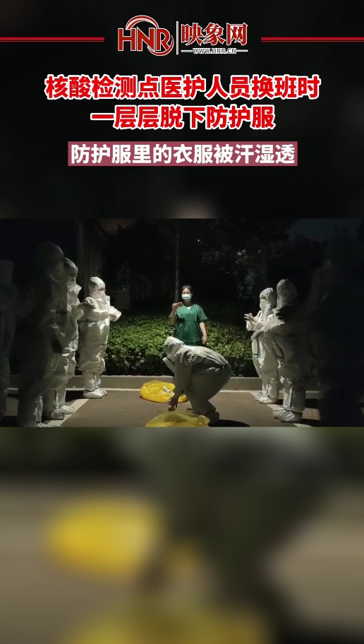 核酸检测点医护人员换班时一层层脱下防护服 防护服里的衣服被汗湿透