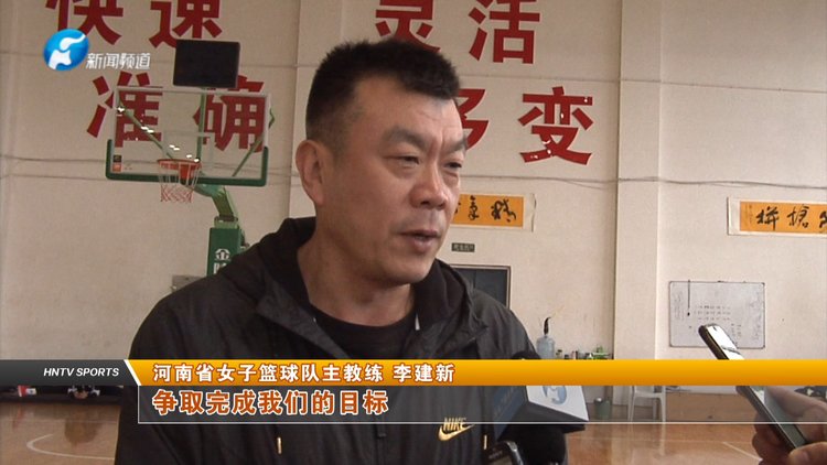 河南女篮主教练李建新一边紧盯场上每一名队员的跑位,打法,一边不时地