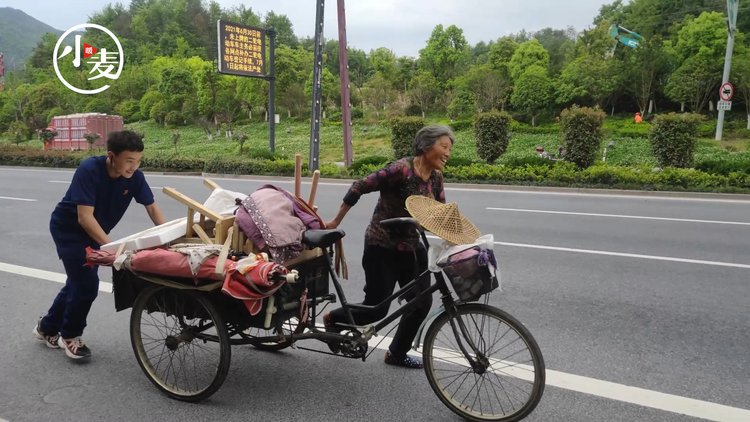 老人推着载满农具的三轮车艰难上坡正在训练的消防员一个举动让大爷